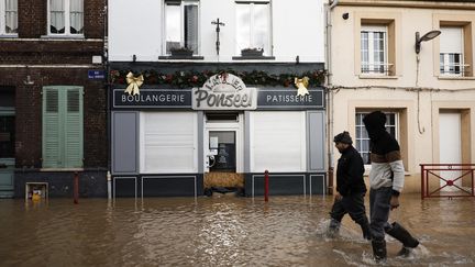 Des habitants dans une rue inondée d'Arques (Pas-de-Calais), le 4 janvier 2024. (AMEER ALHALBI / ANADOLU / AFP)