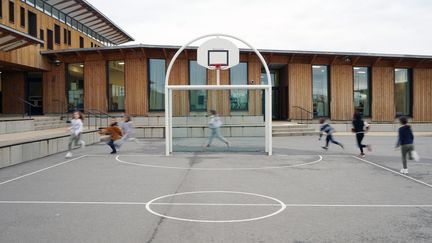 Des élèves de CE2 en plein cours d'EPS dans la cour de leur école à Bruyères-le-Chatel, le 19 janvier 2021. (MYRIAM TIRLER / HANS LUCAS via AFP)