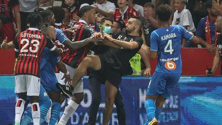 Un supporter de l'OGC Nice tente de frapper Dimitri Payet pendant le match entre Nice et Marseille à l'Allianz Riviera, le 23 août. (VALERY HACHE / AFP)