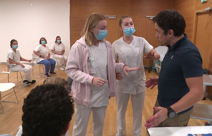 Jérôme Robert, le formateur (à droite, polo noir) joue le rôle de l'accompagnant agressif. Il n'hésite pas à bousculer vraiment les jeunes soignantes pour les mettre en situation réelle.&nbsp; (D. Despin / France Télévisions)