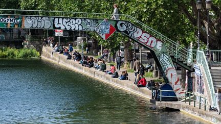 Des Parisiens rassemblés sur le&nbsp;Canal Saint-Martin, à Paris (10e arrondissement), au premier jour du déconfinement, le 11 mai 2020. (SAMUEL BOIVIN / NURPHOTO / AFP)