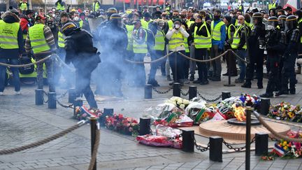 Des manifestants autour de la flamme du "soldat inconnu". (ALAIN JOCARD / AFP)