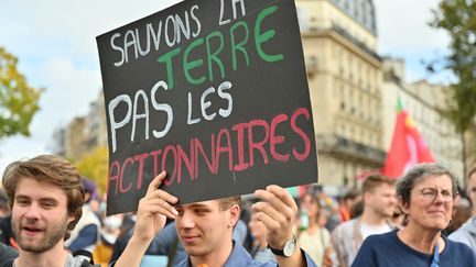 Illustration d une pancarte avec le message "sauvons la terre pas les actionnaires", le 16 octobre 2022 à Paris lors de la marche contre "la vie chère et l'inaction climatique". (HENRIQUE CAMPOS / HANS LUCAS via AFP)