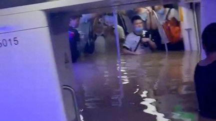 Sur les réseaux sociaux, les images des rames de métro de Zhengzhou submergées ont abondé, montrant des usagers coincés dans les intempéries, recouverts jusqu'à la moitié du corps.&nbsp; (EYEPRESS NEWS / AFP)