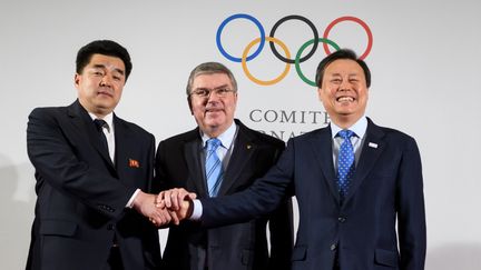 Le président du Comité international olympique, Thomas Bach, au centre, entouré du ministre des Sports nord-coréen, Kim Il-guk (à gauche) et son homoloque sud-coréen, Do Jong-hwan, samedi 20 janvier 2018.&nbsp; (FABRICE COFFRINI / AFP)