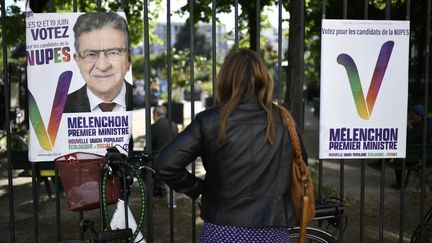 Une femme se tient devant des affiches électorales de la Nupes à Paris le 1er juin 2022. (STEPHANE DE SAKUTIN / AFP)