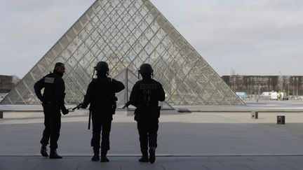 Des policiers devant la pyramide du Louvre après l'agression de militaires, le 3 février 2017. (CHRISTIAN HARTMANN / REUTERS)