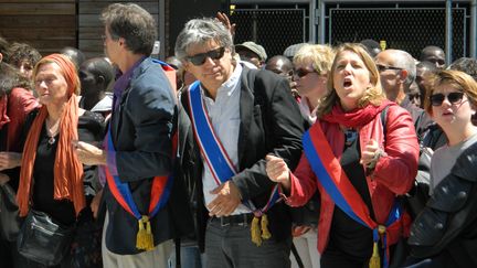 Des &eacute;lus parisiens forment une cha&icirc;ne humaine pour emp&ecirc;cher les forces de l'ordre d'&eacute;vacuer des migrants, devant la halle Pujol, &agrave; Paris, le 8 juin 2015. (JEAN-RAPHAEL BOURGE / CITIZENSIDE.COM / AFP)