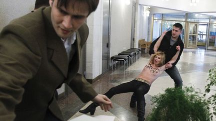 Une activiste ukrainienne de la Femen est &eacute;vacu&eacute;e du bureau de vote dans lequel s'est rendu plus t&ocirc;t le Premier ministre russe Vladimir Poutine &agrave; Moscou (Russie), le 4 mars 2012. (DENIS SINYAKOV / REUTERS)