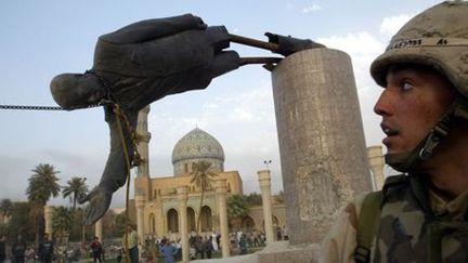 Un militaire américain assiste à la chute de la statue de Saddam Hussein dans le centre de Bagdad, le 9 avril 2003. (REUTERS - Goran Tomasevic - Files )