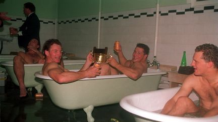 Les rugbymen australiens (au milieu, avec le troph&eacute;e Webb Ellis, figurent Simon Poidevin et Phil Kearns) f&ecirc;tent dans des baignoires leur victoire en Coupe du monde, le 2 novembre 1991 &agrave; Twickenham (Londres). (GETTY IMAGES)