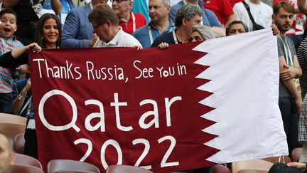 Des personnes brandissent une banderole pour célébrer le Mondial-2022, lors du Mondial en Russie, lors de la finale France-Croatie, le 15 juillet 2018. (SEBASTIAN EL-SAQQA / AUGENKLICK / FIRO SPORTPHOTO / AFP)