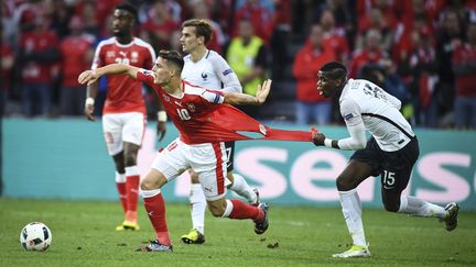 Paul Pogba accroche Granit Xhaka, lors du match entre la France et la Suisse, le 19 juin 2016. (MUSTAFA YALCIN / ANADOLU AGENCY / AFP)