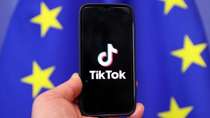 Le logo de TikTok devant un drapeau de l'Union européenne (image d'illustration). (DURSUN AYDEMIR / ANADOLU AGENCY / AFP)