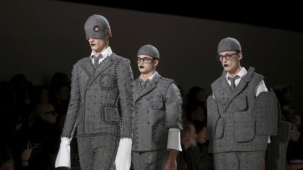 Pour le final, les 3 mannequins défilent côte à côte. Le costume terminé est, enfin, visible avec ses 2 ébauches qui ont permis sa construction. Ce n'est pas la première fois que Thom Browne utlise ce procédé. En janvier 2016, dans son défilé consacré au temps qui passe et à l'usure qu'il produit sur le vêtement, trois mannequins habillés du même vêtement défilaient ensemble portant un vêtement neuf, un second un peu usé et le troisième totalement élimé. 
 (Thibault Camus/AP/SIPA)