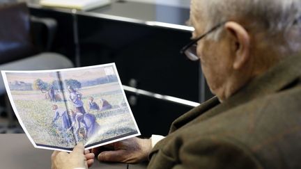 Jean-Jacques Bauer, descendant de Simon Baurer, regardant une reproduction de la gouache "La cueillette", de Pissarro, confisquée pendant l'Occupation
 (Thibault Camus/AP/SIPA)