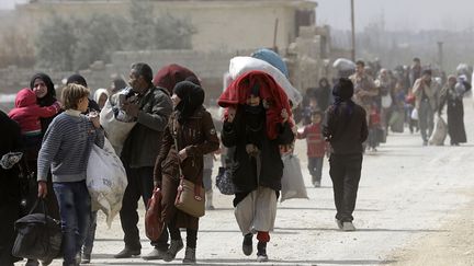 Des&nbsp;Syriens fuient&nbsp;l'enclave rebelle de la Ghouta orientale, le 15 mars 2018. (LOUAI BESHARA / AFP)