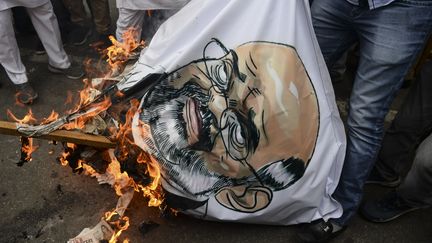 Un portrait du ministre de l'Intérieur indien,&nbsp;Amit Shah, brûlé par de jeunes activistes lors d'une manifestation le 2 mars 2020. (SAJJAD HUSSAIN / AFP)