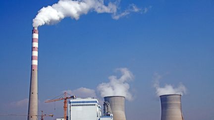 Smoke and steam are vented from a chimney and cooling towers at a coal-fired power plant in the city of Baishan, China, October 6, 2014. (DING DONG / IMAGINECHINA / AFP)