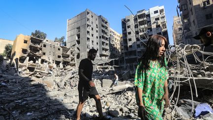 Des personnes marchent parmi les décombres d'immeubles détruits par des frappes israéliennes, le 29 septembre 2024 à Beyrouth (Liban). (AFP)