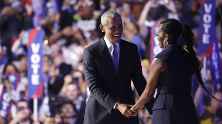 Barack et Michelle Obama lors de leur passage de témoin, à la tribune de la convention démocrate, le 20 août 2024 à Chicago (Etats-Unis). (KEVIN DIETSCH / GETTY IMAGES NORTH AMERICA/ AFP)