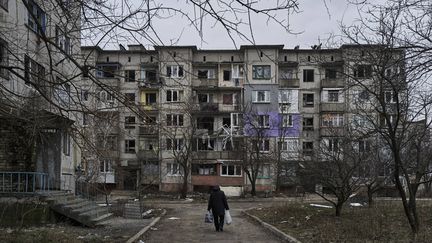 Un habitant de Soledar (est de l'Ukraine) circule dans un quartier de la ville, le 21 décembre 2022. (LIBKOS / AP / SIPA)