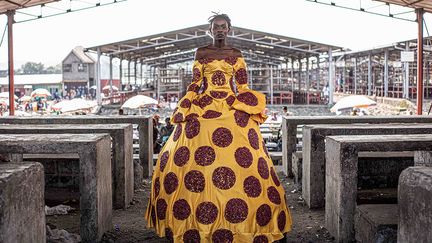 Dans sa dernière série "Enfer paradisiaque" (2021), la photographe s’est interrogée pendant la période du Covid-19 sur le paradoxe de son pays aux ressources abondantes, "le paradis sur terre" pourtant réputé comme étant l’enfer. Quels sont les besoins indispensables des gens pour survivre en situation de crise (électricité, nourriture…)&nbsp;?, questionne Pamela Tulizo. Pour illustrer cette démarche, elle a amené ses modèles dans des endroits populaires de Goma, habillées de somptueuses robes brodées de produits essentiels comme le charbon, les allumettes ou les ampoules.&nbsp; &nbsp; (PAMELA TULIZO)