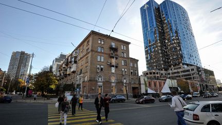 People walk past the partially destroyed building of a business center damaged by a rocket attack in central Kiev, October 17, 2022. (EUROPEAN UNION / HANS LUCAS / AFP)