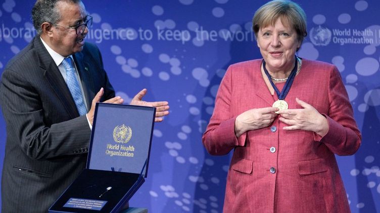 German Chancellor Angela Merkel receives a medal from Tedros Adhanom Ghebreyesus, Director-General of the WHO, during the inauguration ceremony of the Epidemic Research and Detection Center in Berlin on 1 September 2021 (MICHAEL SOHN / AP / AFP)