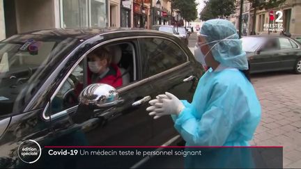 Une médecin pratique un test de dépistage du coronavirus via un drive médical, en mars 2020 à Neuilly-sur-Seine (Hauts-de-Seine). (FRANCE 2)