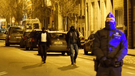 Des policiers perquisitionnent dans un quartier de Bruxelles, le 30 décembre 2015. (CITIZENSIDE / OLIVIER GOUALLEC / AFP)