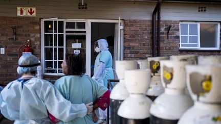 Un soignant aide une patiente du Covid-19 à regagner sa chambre dans un centre de soins Covid à Norwood, Johannesburg, le 12 juillet 2021. (EMMANUEL CROSET / AFP)