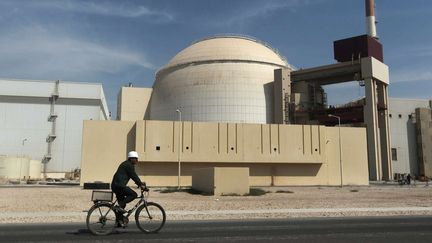 Un homme &agrave; v&eacute;lo passe devant la centrale nucl&eacute;aire de Bushehr, dans le sud de l'Iran, le 26 octobre 2010. (MAJID ASGARIPOUR/AP/SIPA)