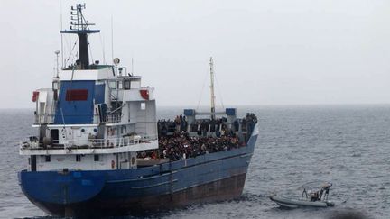 Des migrants secourus par un navire marchand, le 20 novembre 2014, pr&egrave;s des c&ocirc;tes de la Sicile (Italie). (MARINA MILITARE ITALIANA / AFP)