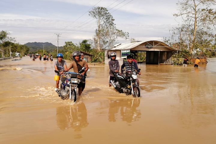 Des habitants affrontent les eaux après de fortes précipitations dues au passage du typhon Phantone, mercredi 25 décembre 2019 à Ormoc (Philippines). (RONALD FRANK DEJON / AFP)