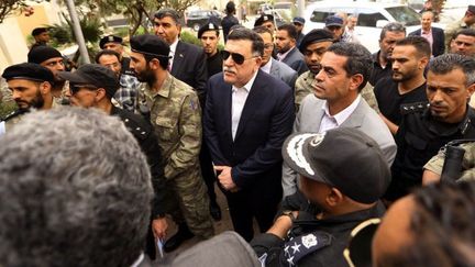 Le chef du gouvernement libyen d'union nationale, Fayez al-Sarraj, en visite au siège de la commisssion électorale à Tripoli après l'attentat kamikaze revendiqué par l'organisation de l'Etat islamique le 2 mai 2018, qui a fait 12 morts et 7 blessés.  (MAHMUD TURKIA/AFP)