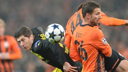 Razvan Rat (Donetsk) à la lutte avec Robert Lewandowski (Dortmund) (SERGEI SUPINSKY / AFP)