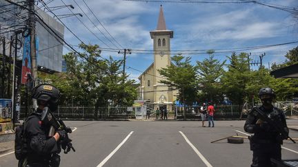 La police indonésienne monte la garde devant une église après une explosion à Makassar, le 28 mars 2021. (INDRA ABRIYANTO / AFP)