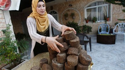 Faeda Yamak est une Palestinienne en plein travail. Avec d'autres femmes du village de Beita, en Cisjordanie, elles produisent des briques de déchets environnementaux comme combustible de substitution au bois de chauffage. Une occupation qui génère des emplois en Territoire palestinien et pousse les femmes, de manière générale, à exercer une activité professionnelle.
