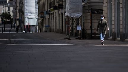 Une femme portant un masque, dans les rues de Nantes (Loire-Atlantique), le 29 mars 2020. (LOIC VENANCE / AFP)