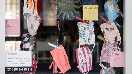 Des masques en tissu pour adultes et enfants dans une vitrine d'un magasin de Hambourg (Allemagne), le 21 avril 2020. (BODO MARKS / DPA / AFP)