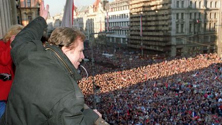 Vaclav Havel salue des milliers de personnes r&eacute;unies sur la place place Venceslas de Prague,&nbsp;le 10 d&eacute;cembre 1989, pour saluer la chute du communisme. Il devient pr&eacute;sident de la Tch&eacute;voslovaquie quelques jours plus tard, le 29 d&eacute;cembre. (LUBOMIR KOTEK /&nbsp;AFP PHOTO)