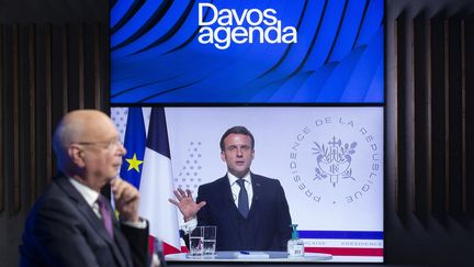 Visioconférence du Forum de Davos. Klaus Schwab, fondateur de ce Forum (à gauche) et Emmanuel Macron, président de la République, sur l'écran (à droite), le 26 janvier 2021. (SALVATORE DI NOLFI / KEYSTONE)