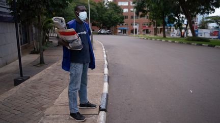 Un vendeur de journaux, dans les rues désertées de Kigali, soumises aux mesures de confinement face à la pandémie de coronavirus, le 22 mars 2020.&nbsp; (SIMON WOHLFAHRT / AFP)