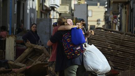 Deux femmes se prennent dans les bras jeudi 31 octobre à Alfafar, après les crues meurtrières survenues dans la région de Valence. (JOSE JORDAN / AFP)