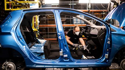 Un&nbsp;salarié de Renault sur une ligne d'assemblage de l'usine de Flins (Yvelines), le 6 mai 2020. (MARTIN BUREAU / AFP)