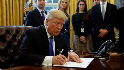 Le président américain Donald Trump signe un décret sur la construction de l'oléoduc Keystone XL, à la Maison&nbsp;Blanche, à Washington, le 24 janvier 2017. (KEVIN LAMARQUE / REUTERS)