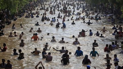 Des hommes se rafra&icirc;chissent dans l'eau du canal &agrave; Lahore (Pakistan) alors que la temp&eacute;rature atteint les 44&deg;C, le 3 juin 2012. (MOHSIN RAZA / REUTERS)