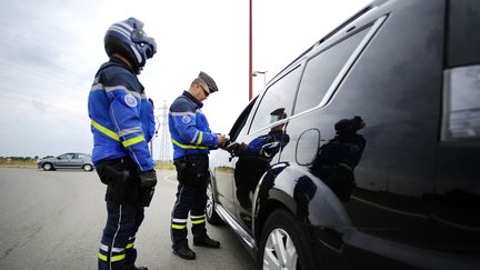 Un gendarme contrôle un automobiliste, le 1er juin 2014&nbsp;au Pellerin (Loire-Atlantique). (JEAN-SEBASTIEN EVRARD / AFP)