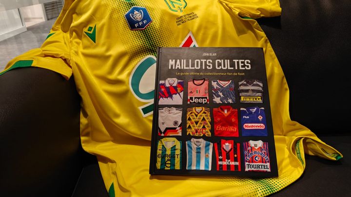 Un exemplaire du livre "Maillots cultes" publié aux éditions Place des victoires en 2024 devant un maillot du FC Nantes porté lors de la finale de la Coupe de France 2022. (FRANCEINFO: SPORT)